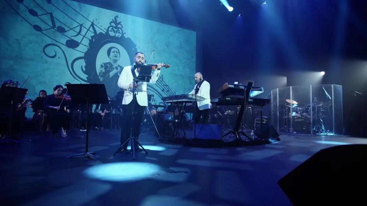 Jad and Rabih with the full orchestra beneath a projection of Umm Kulthum, at the 2026 concert