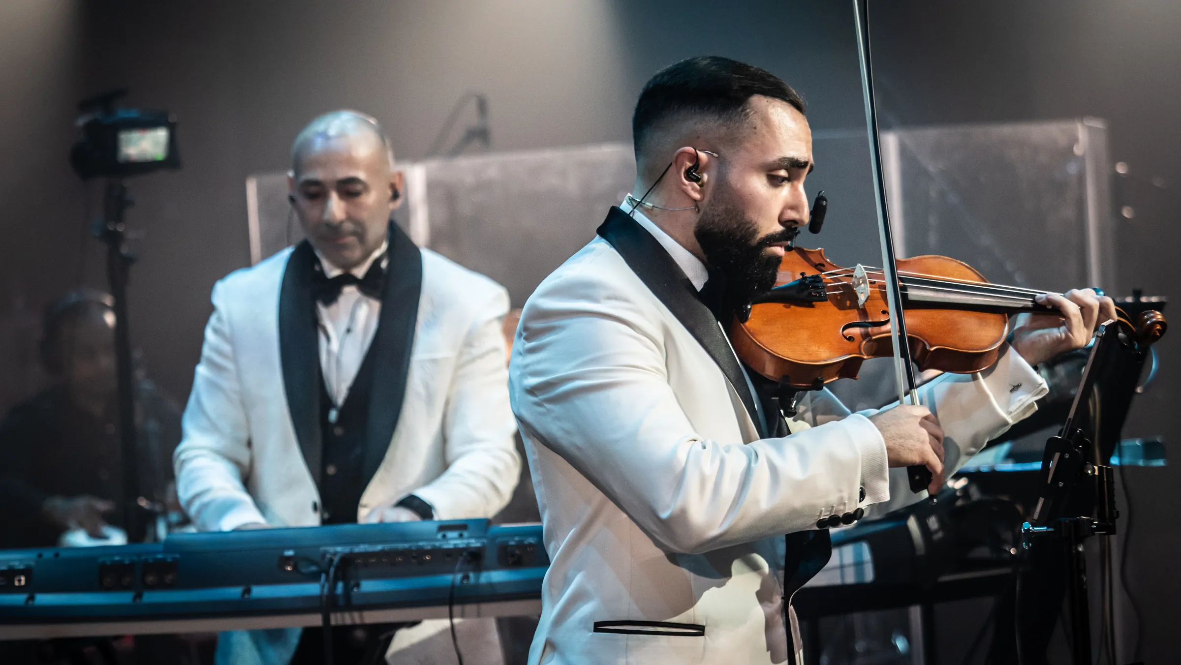 Rabih at the keys and Jad on violin, side by side in white dinner jackets