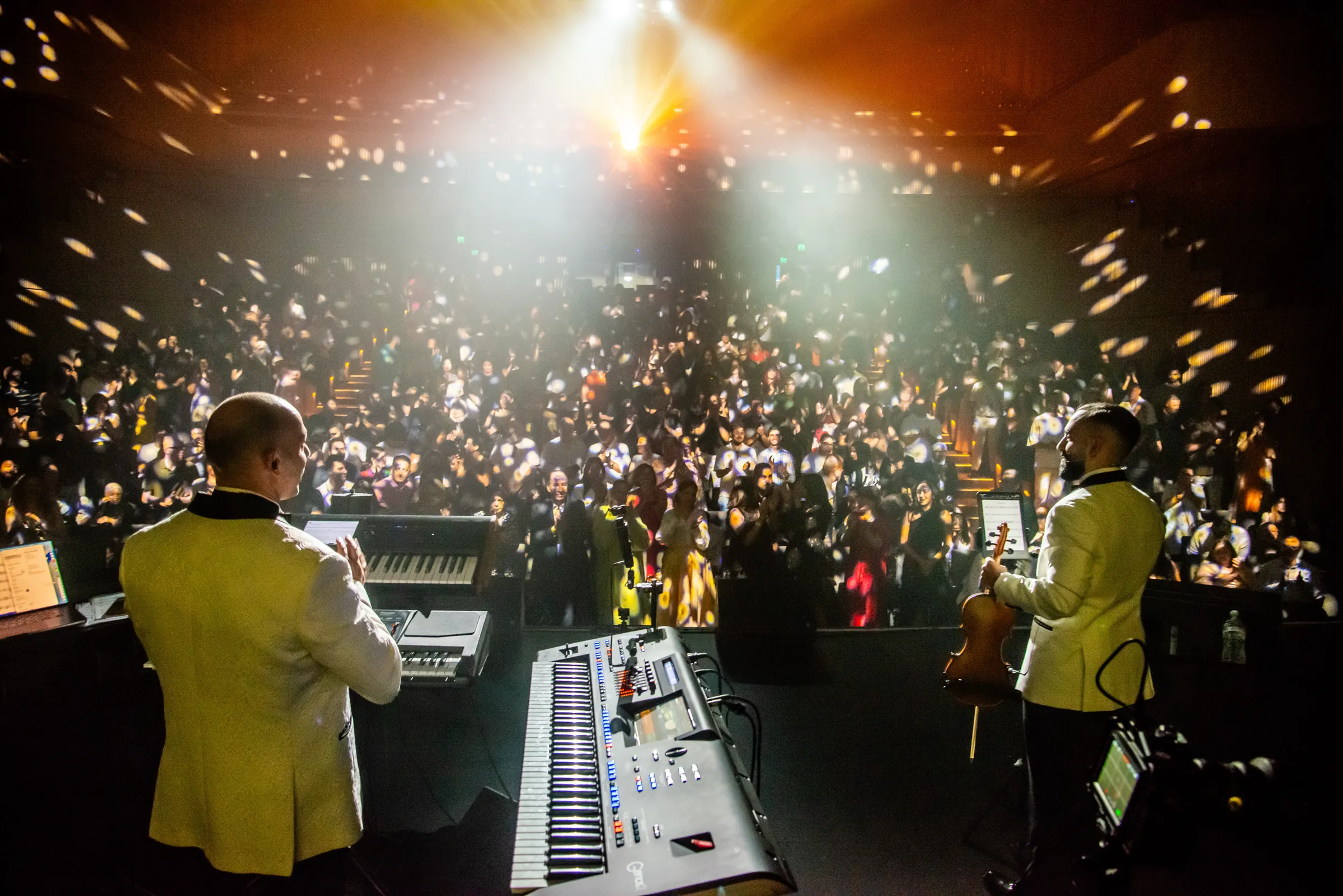 The 2026 audience seen from the stage, in warm light