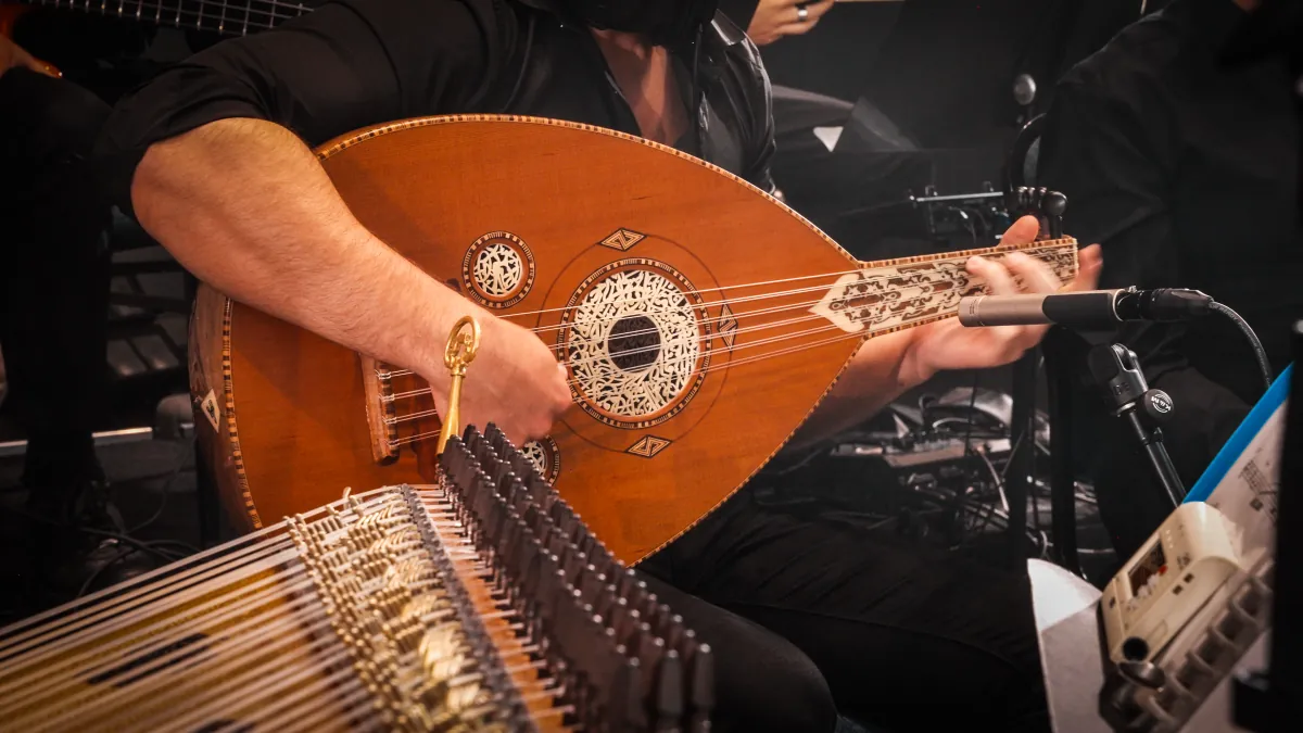 Close-up of an oud being played beside a qanun