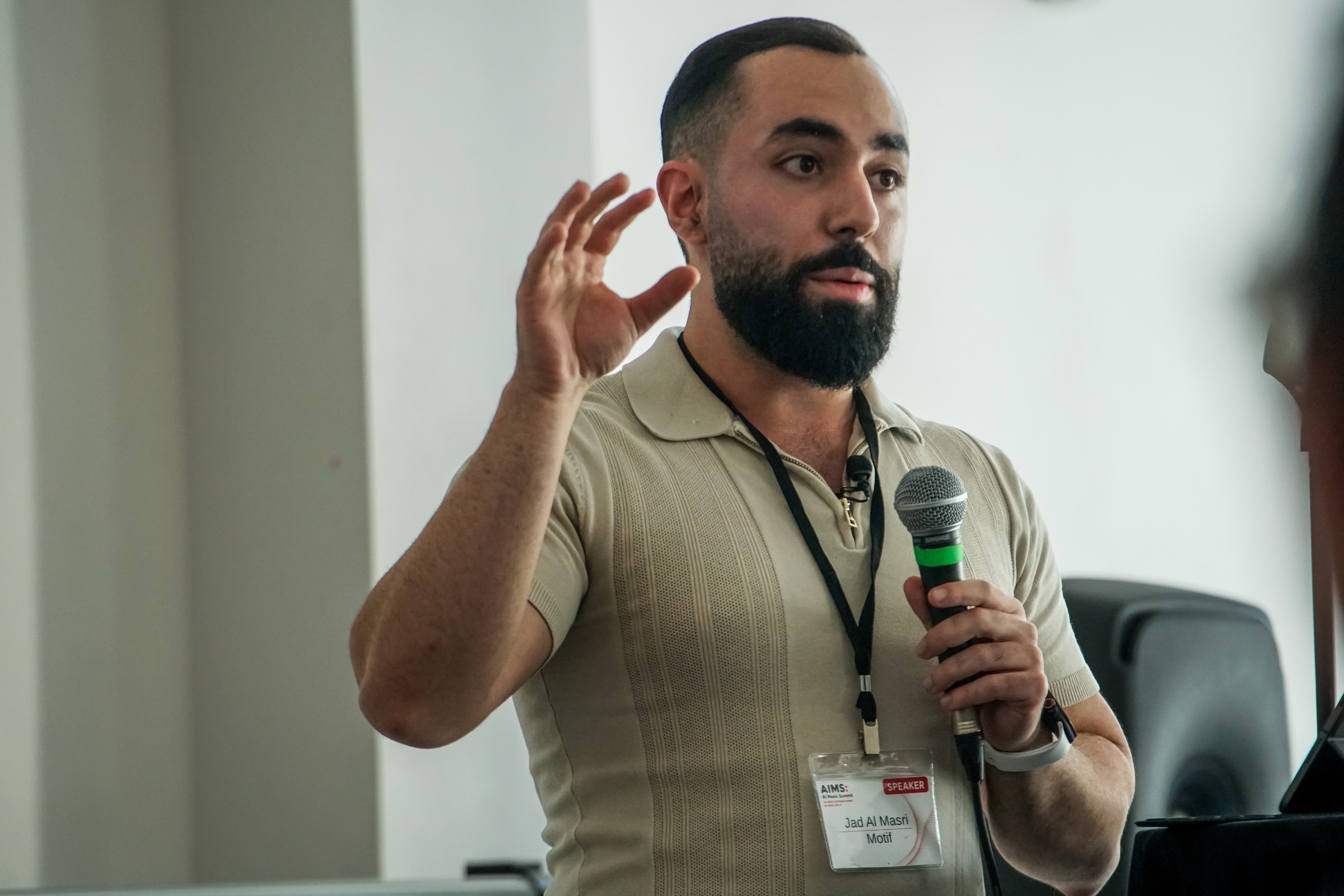 Jad speaking with a microphone in hand at the Berklee AI Music Summit